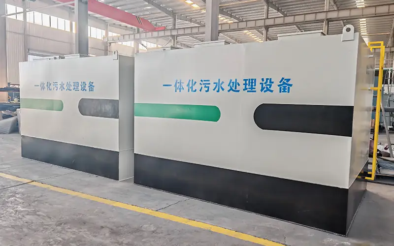 Two integrated wastewater treatment plant units (labeled: 一体化污水处理设备) in factory, ready for on-site sewage treatment projects.