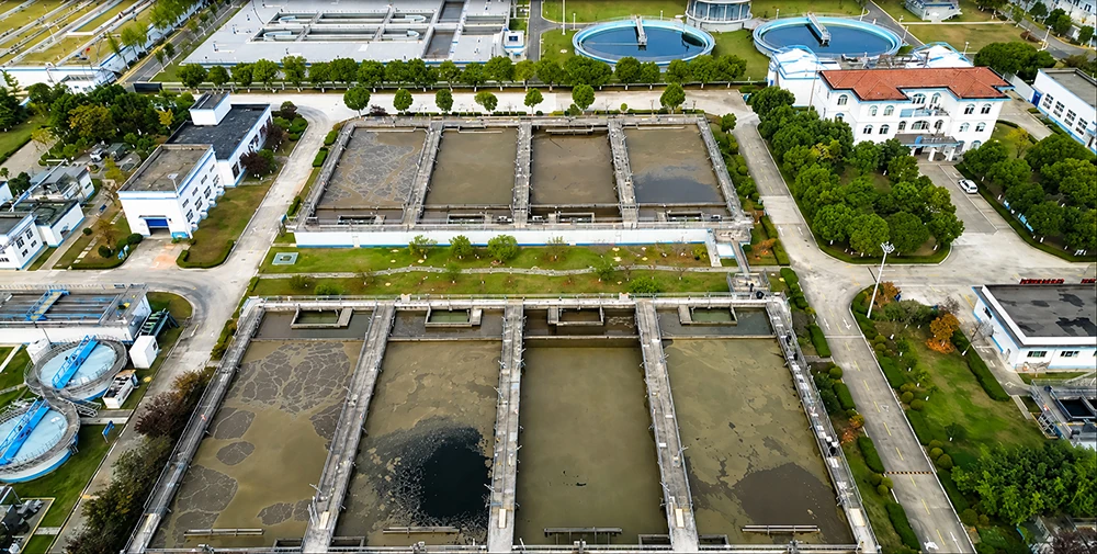 Aerial view showing the process layout and clarification tanks of a municipal wastewater treatment plant