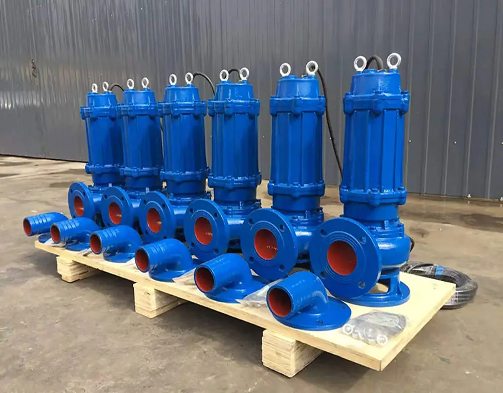 Blue submersible sewage pumps with flanged discharge outlets on a wooden pallet