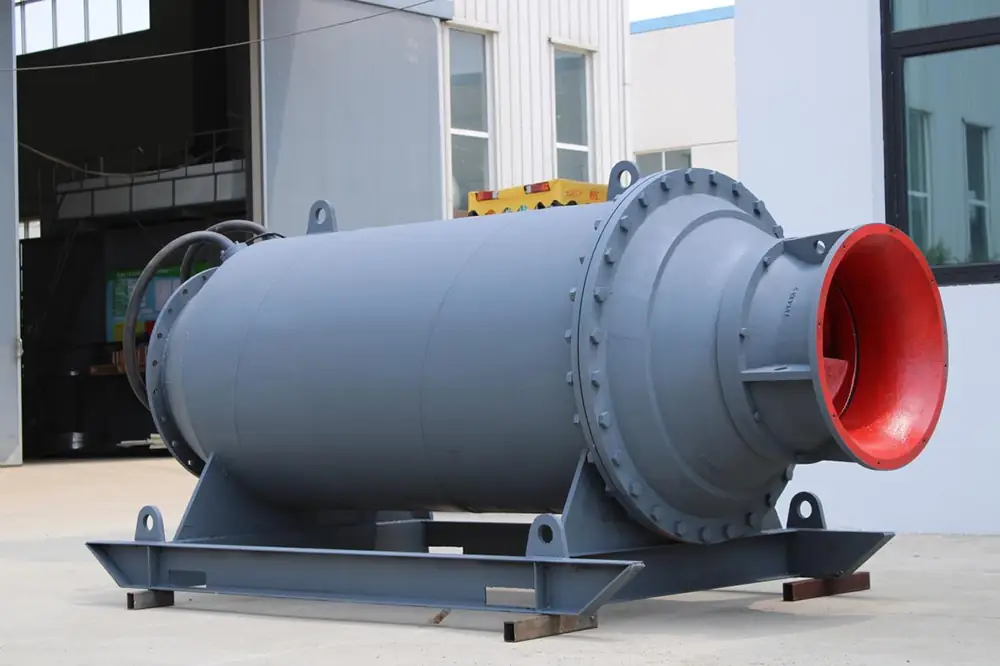 Large horizontal centrifugal pump with a red-lined flanged discharge outlet installed on a steel base frame outside an industrial facility.